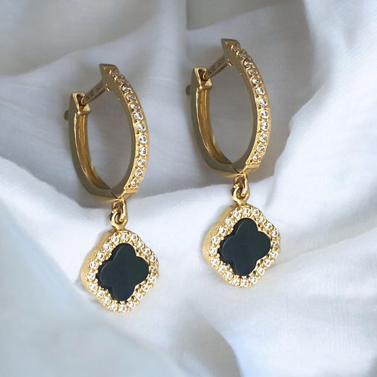 Elegant 14k yellow gold hoop earrings featuring black clover charms with sparkling crystal accents.