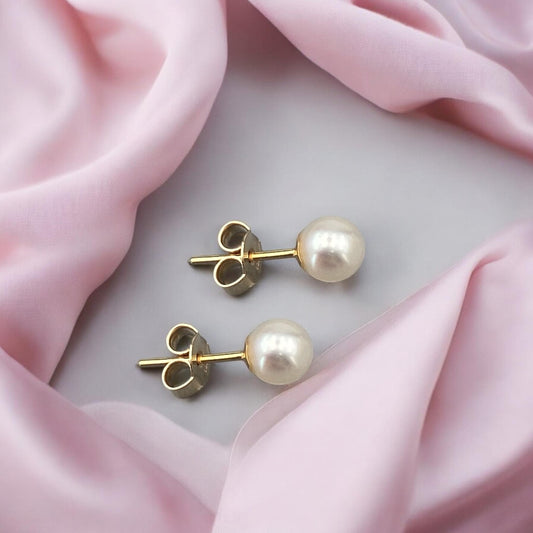 Elegant 14k yellow gold stud earrings featuring a classic pearl design with a polished finish and secure post fastening.
