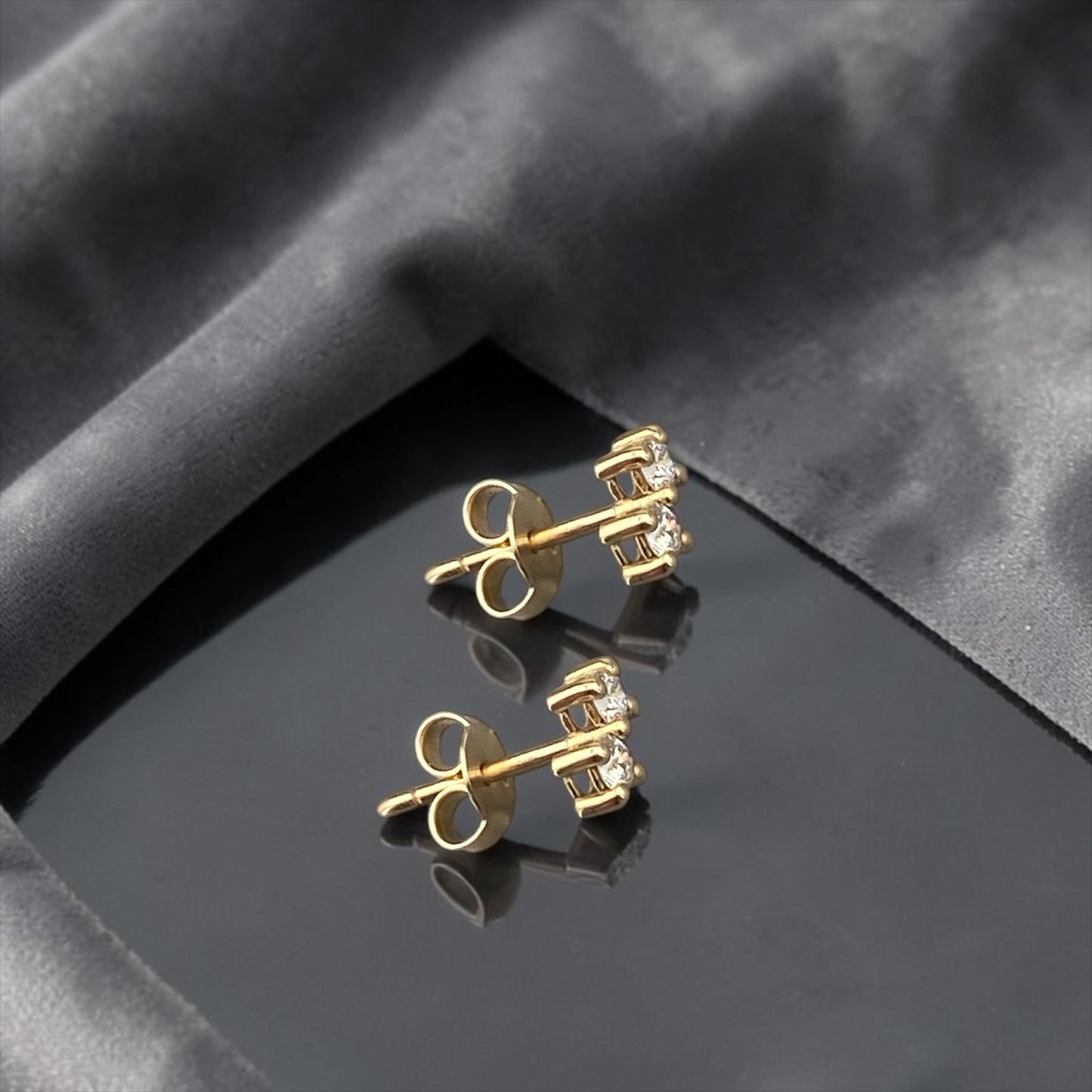 Minimalist 14k yellow gold stud earrings featuring two sparkling lab-grown diamonds in a sophisticated tiered setting.