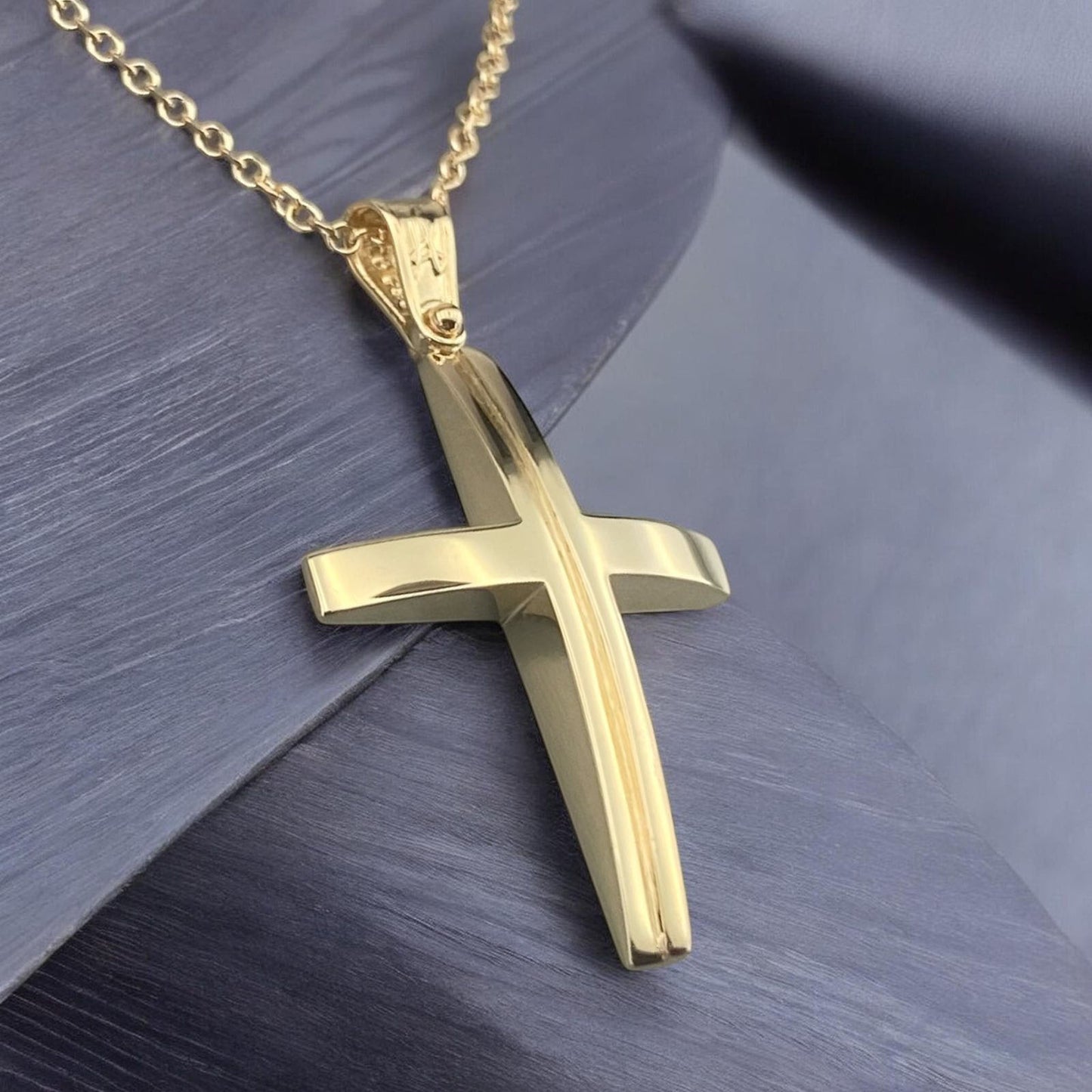 A 14K yellow gold men's cross pendant featuring a unique and elegant center design detail.