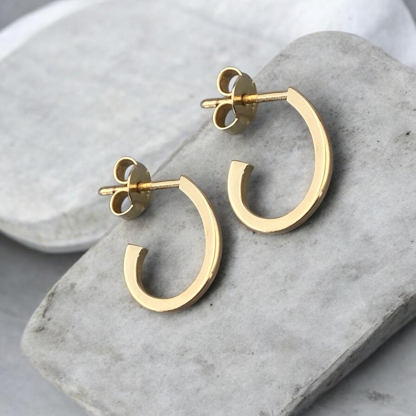 Modern 14k yellow gold half hoop earrings with a minimalist open design.