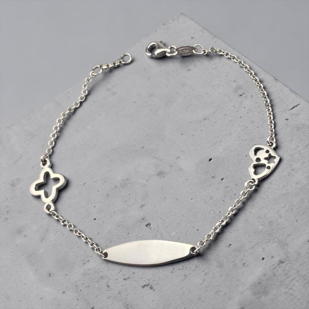 Children's 14k white gold ID bracelet featuring a clover charm and a heart charm with star cut-outs by Glamour Dainty Jewels, delicate baby jewelry.
