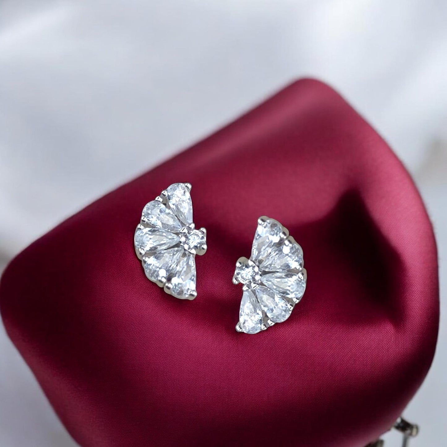 Elegant 14k white gold stud earrings featuring a fan-shaped design with sparkling baguette and round crystals.