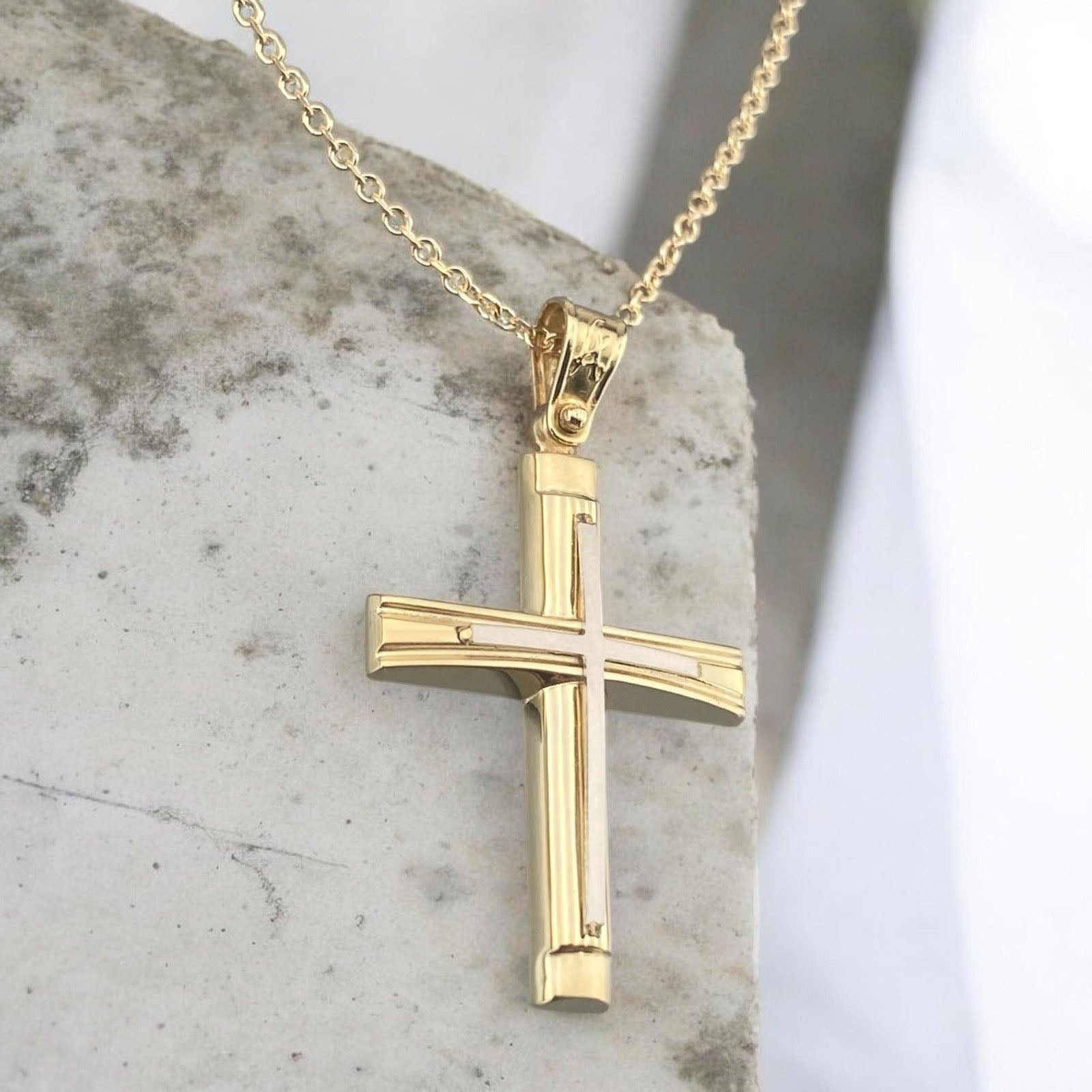 A detailed view of a 14K yellow and white gold men's cross pendant featuring a polished inlay cross design