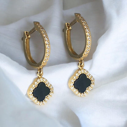 Elegant 14k yellow gold hoop earrings featuring black clover charms with sparkling crystal accents.