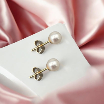 Elegant 14k yellow gold stud earrings featuring a classic pearl design with a polished finish and secure post fastening.