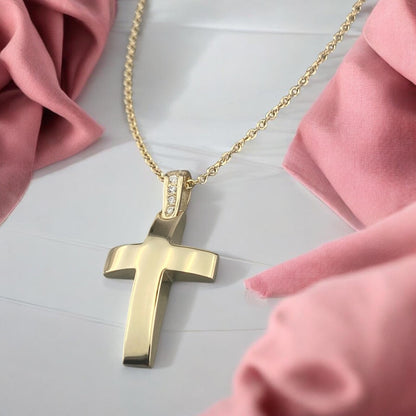 14k yellow gold cross pendant for women, featuring a smooth polished surface and sparkling zirconia stones set on the bail.