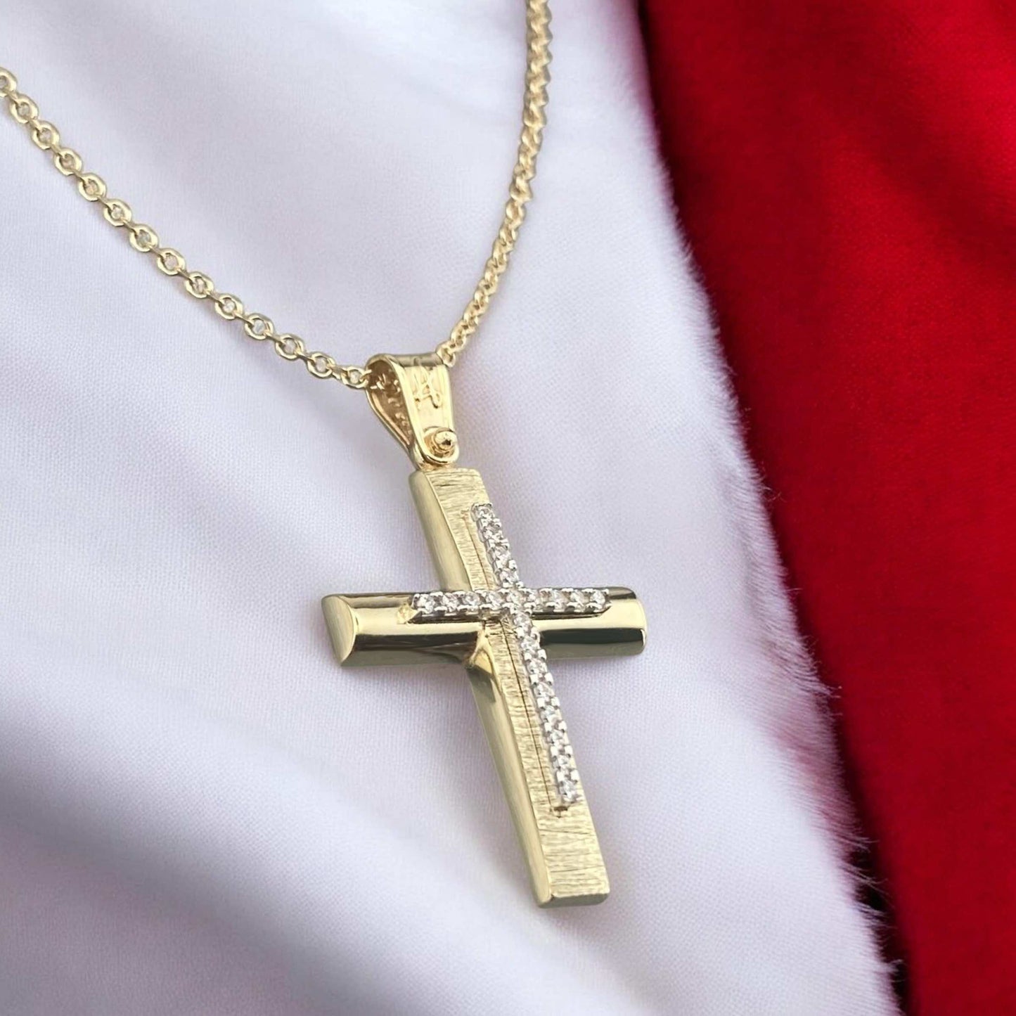 14k yellow gold cross pendant for women, featuring a high-polish finish with shimmering pave-set zirconia stones at the tips and on the bail.