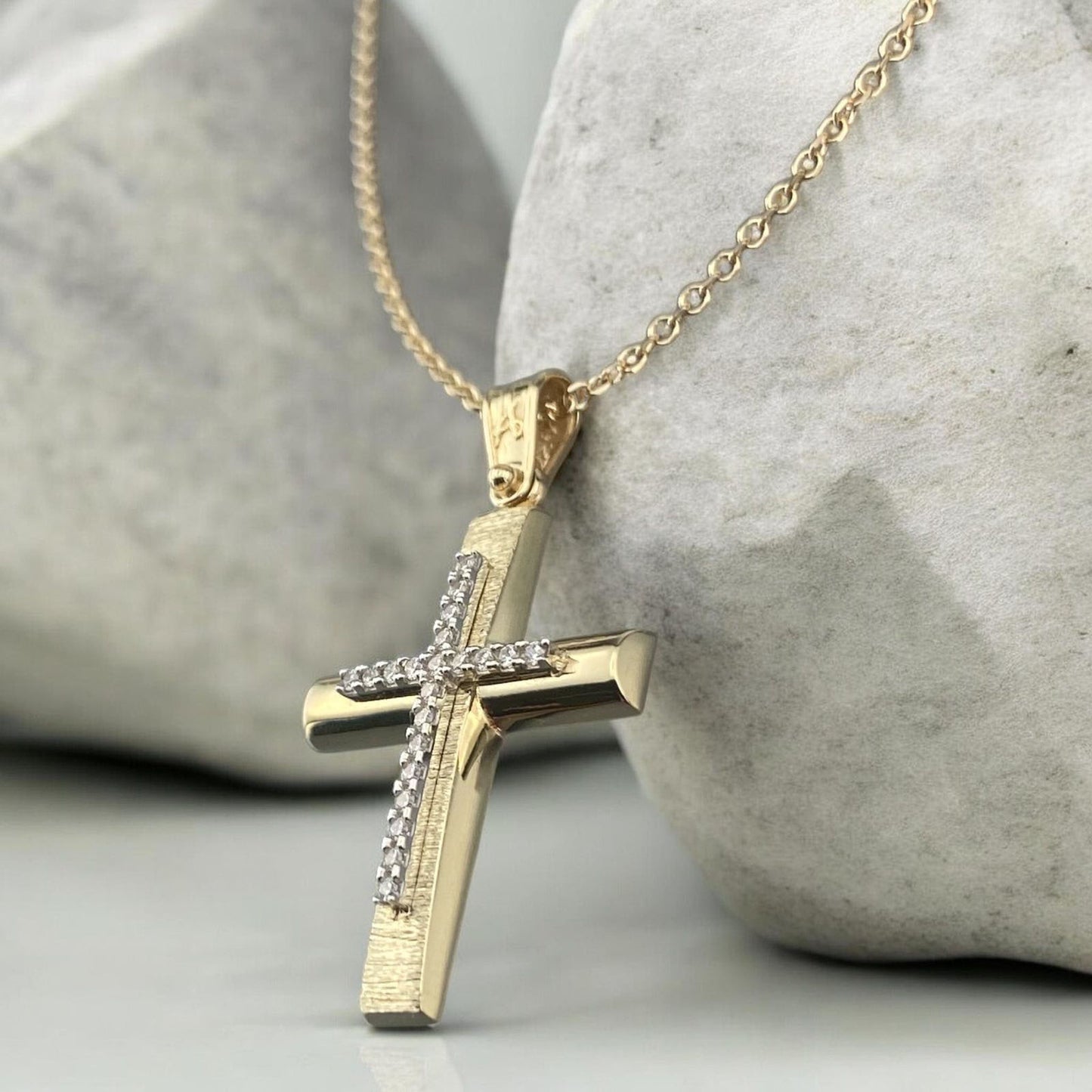14k yellow gold cross pendant for women, featuring a high-polish finish with shimmering pave-set zirconia stones at the tips and on the bail.