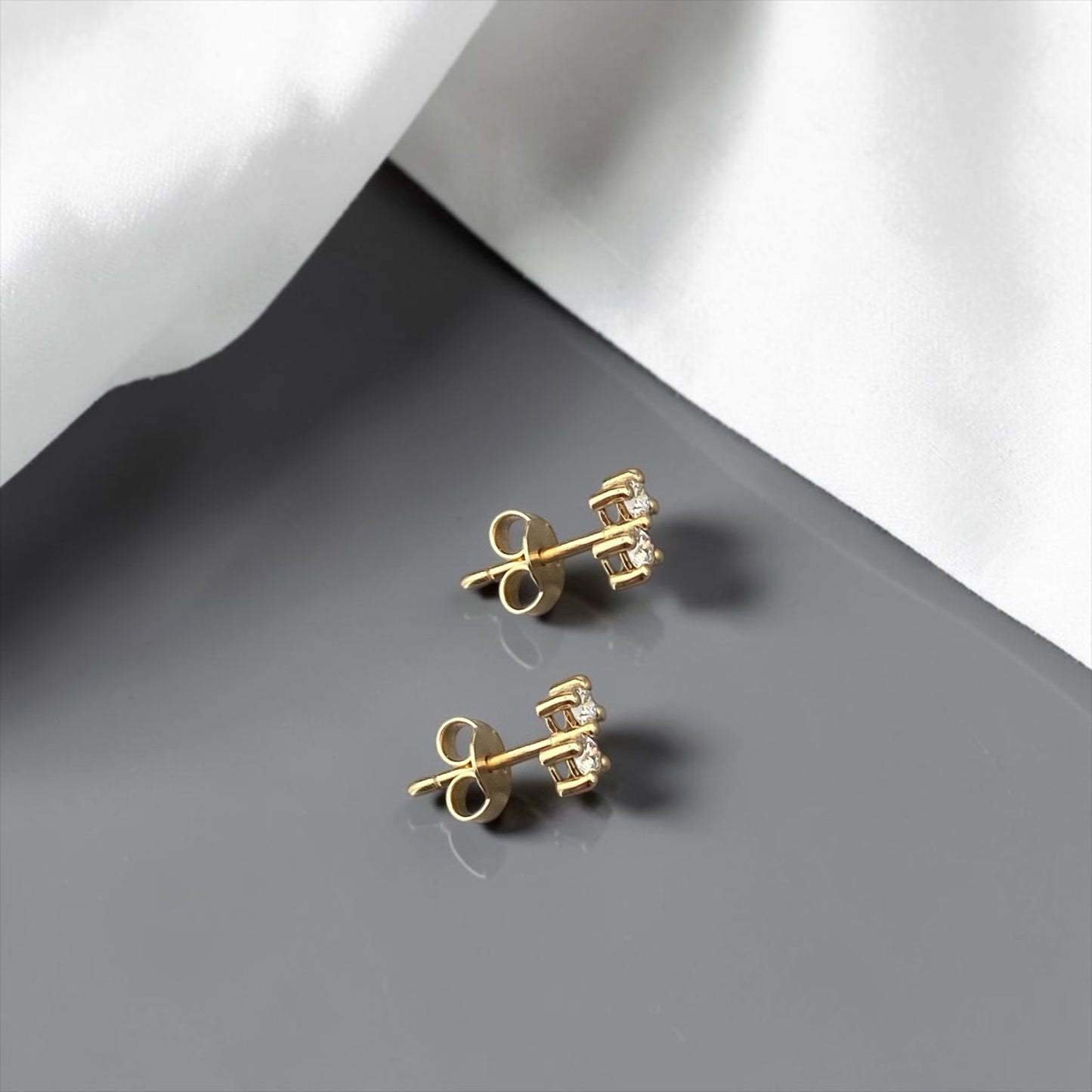 Minimalist 14k yellow gold stud earrings featuring two sparkling lab-grown diamonds in a sophisticated tiered setting.