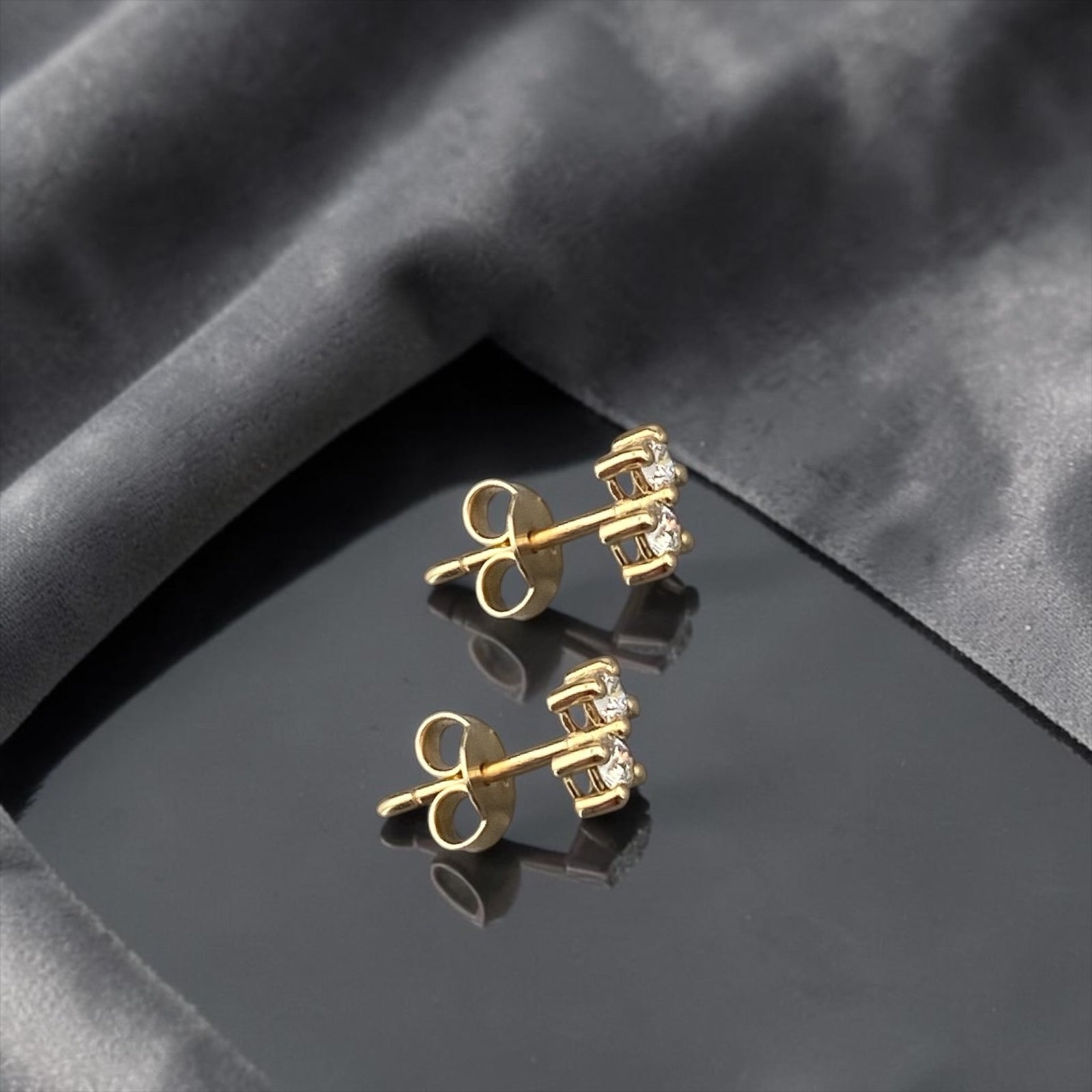 Minimalist 14k yellow gold stud earrings featuring two sparkling lab-grown diamonds in a sophisticated tiered setting.