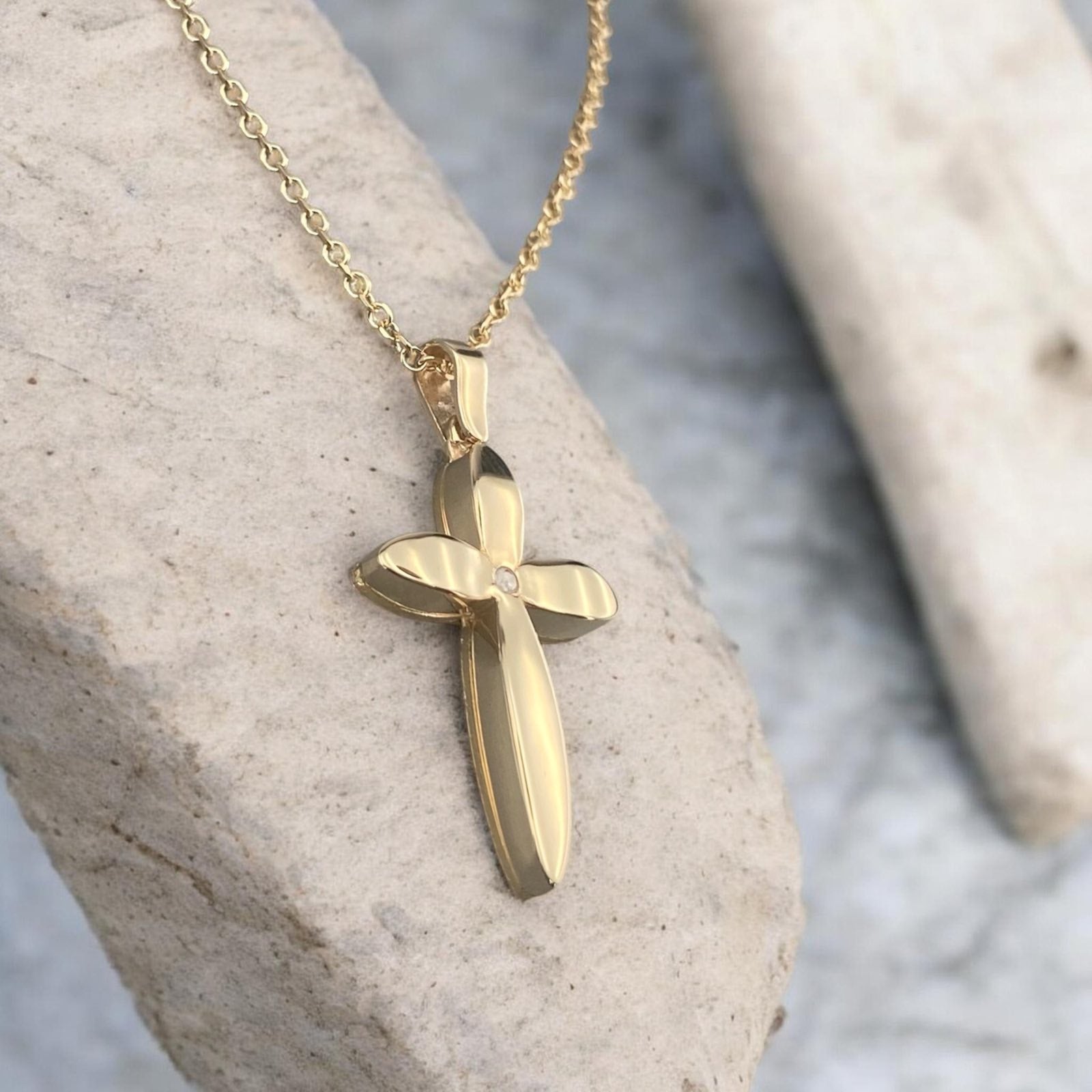 14k yellow gold cross pendant for women, featuring a unique floral-inspired petal design with a central sparkling zirconia stone.