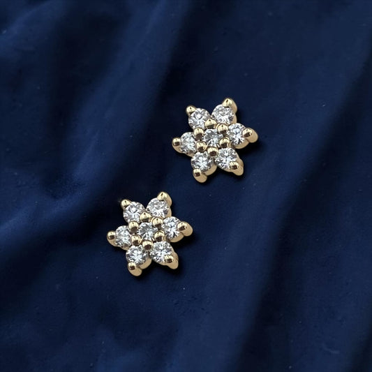 Elegant 14k yellow gold stud earrings featuring a delicate floral or star-shaped design encrusted with sparkling lab-grown diamonds.