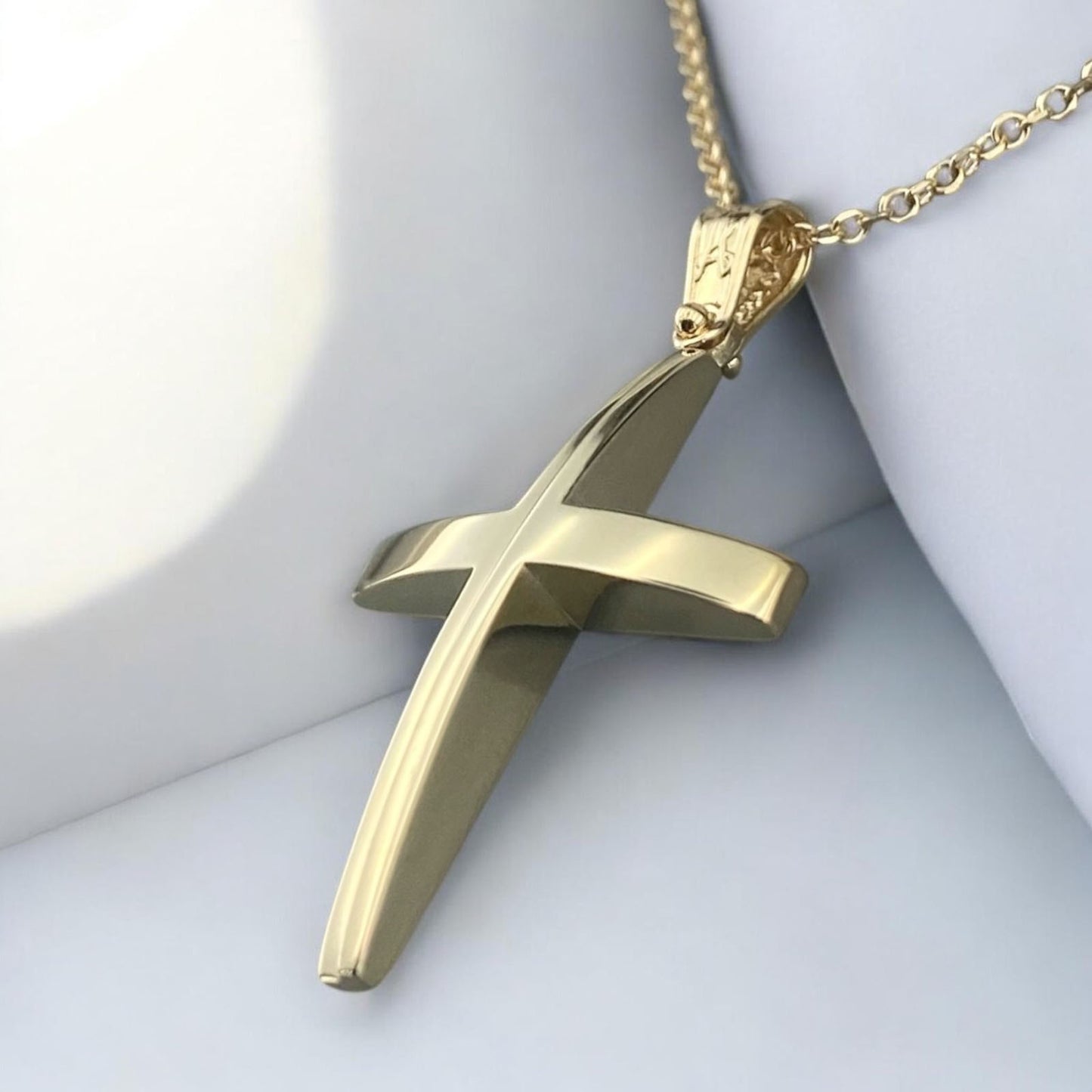 A 14K yellow gold men's cross pendant featuring a unique and elegant center design detail.