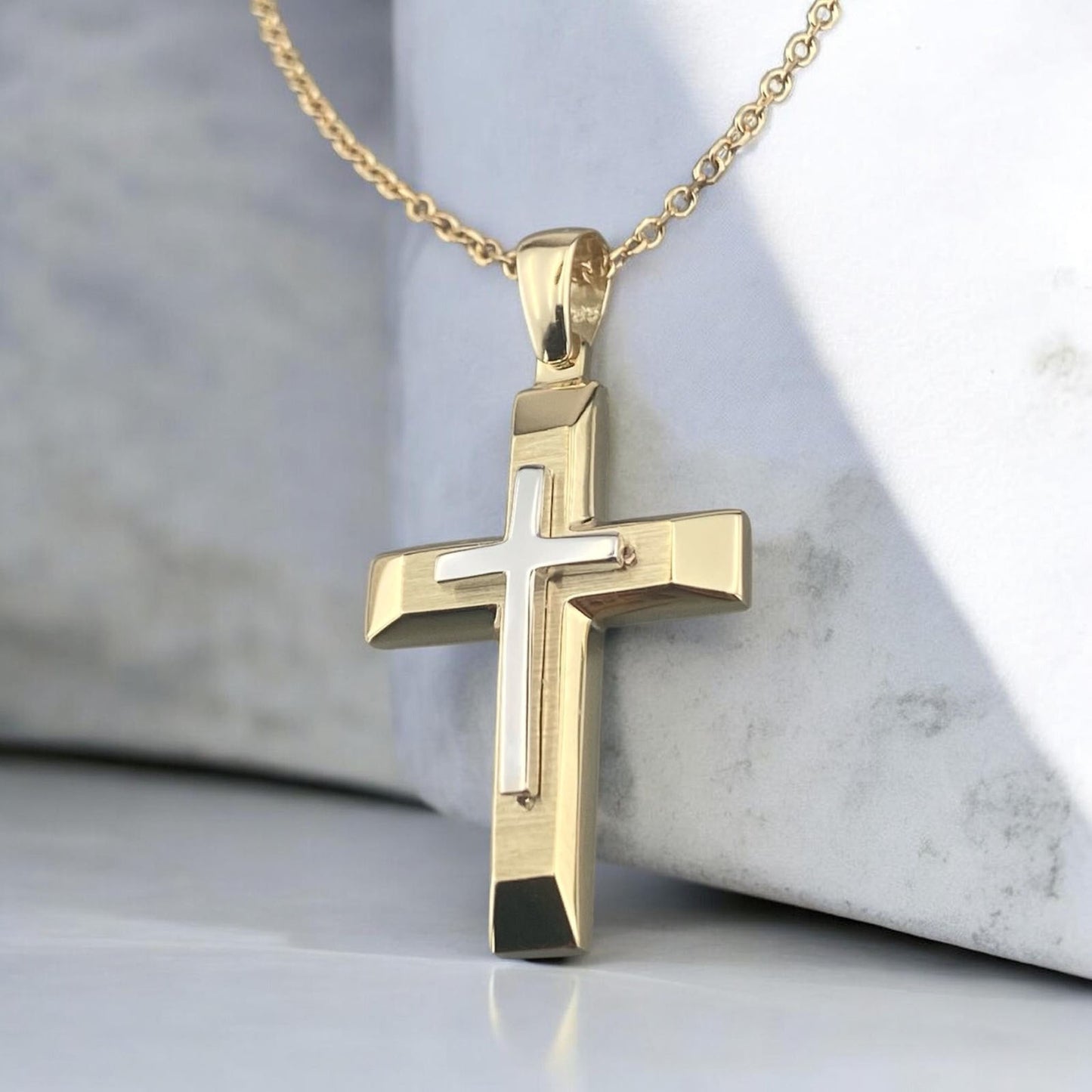 A 14K yellow gold men's cross pendant featuring a white gold inlay, combined with a unique matte and polished finish design.