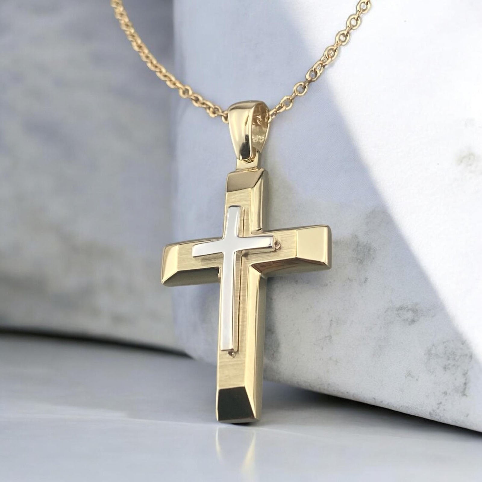 A 14K yellow gold men's cross pendant featuring a white gold inlay, combined with a unique matte and polished finish design.