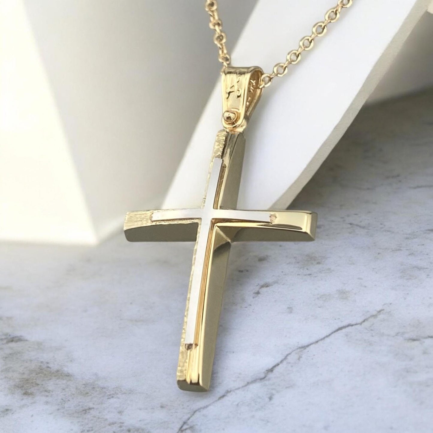 A 14K yellow gold men's cross pendant featuring a white gold inlay, combined with a unique matte and polished finish design.