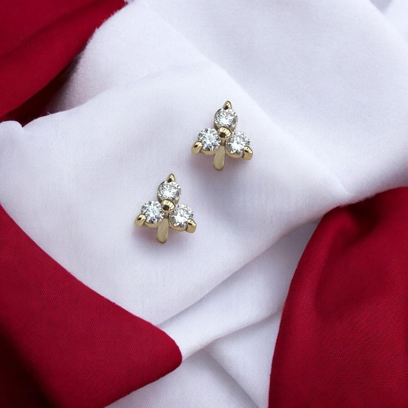 Elegant 14k yellow gold stud earrings featuring a delicate trio arrangement of sparkling lab-grown diamonds.