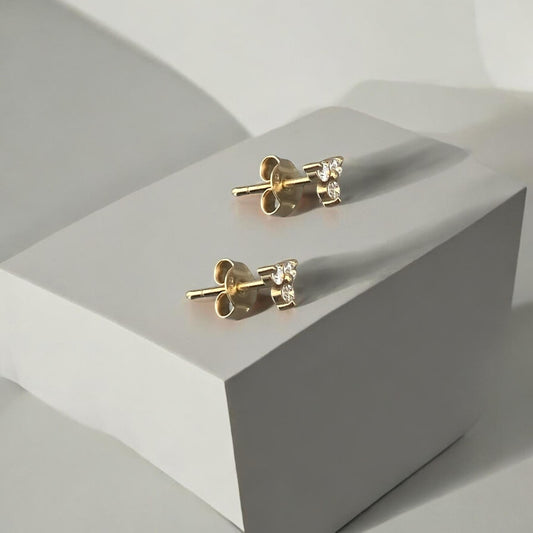 Elegant 14k yellow gold stud earrings featuring a delicate trio arrangement of sparkling lab-grown diamonds.