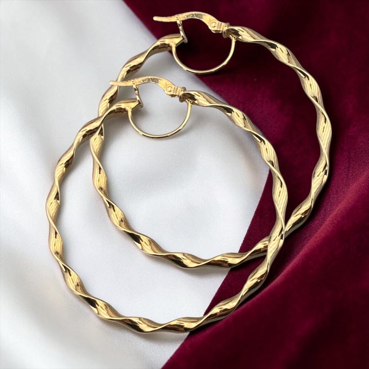 Stylish 14k yellow gold large hoop earrings featuring a twisted textured design with an elegant polished finish.